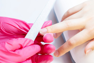 manicurist uses a manicure nail file to process the nail plate and nail file