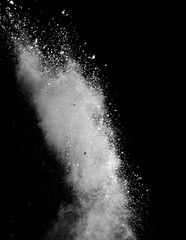 White powder splash isolated on black background. Flour sifting on a black background. Explosive powder white