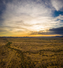 A vertical panorama of a sunset over the Sonoran Desert take by a drone with lots of colorful clouds on the horizon