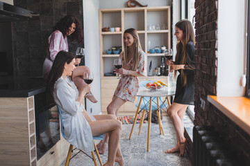 Multi ethnic ladies in amazing stylish pajamas enjoy the time together in a modern apartment design...
