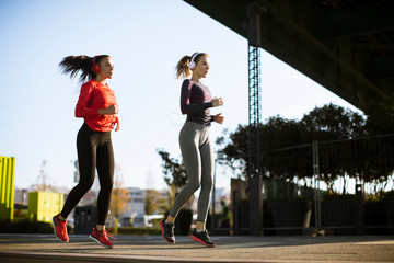 Scenery of two female joggers pursuing their activity outdoors in the city