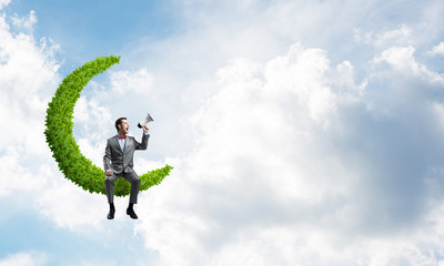 Businessman or manager in blue day sky announcing something in loudspeaker