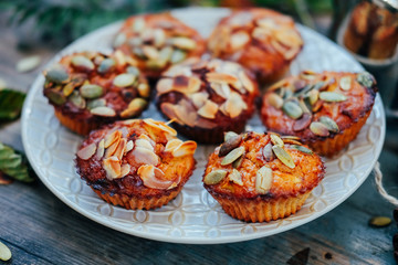 Healthy fall vegetarian dessert. Apple cupcake with pumpkin, almond seeds and spices.