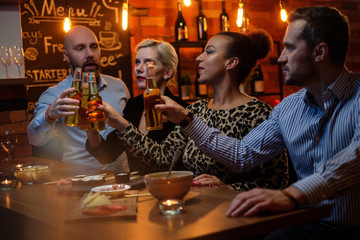 Group of friends watching tv in a cafe behind bar counter