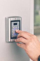 Man hand pressing the security code combination to unlock the door