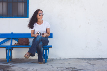 Photographer sitting on a bench with an old analog photography camera in her hands