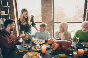 Happy thanksgiving. Photo of big family gathering sit feast meals dinner table wife giving everybody fresh baked bread multi-generation in evening living room indoors