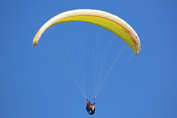 Paraglider flying wing in a blue sky