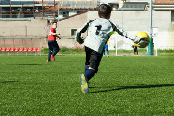 Child goalkeeper in action during a football match