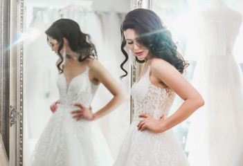 Beautifu bride choosing wedding dress in a wedding salon