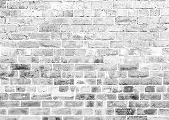 pale grey monochrome image of an old rough brick wall