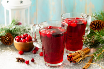 Christmas drinks. Hot winter drink with cranberries and cinnamon on a light stone table. Free space for your text.