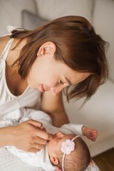 Obraz na płótnie Canvas Close-up. Cute newborn baby sleeping in mother's arms. Motherhood.