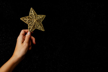 Christmas flat lay. Gold star in hand.