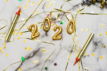 The concept of the new 2020 and Christmas. Gold numbers 2020, spangles and garlands on a marble background. top view, flat lay