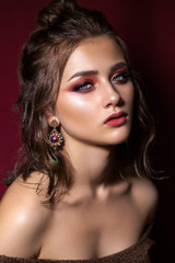 Attractive young model colorful trendy smoky eyes, bright blue eyes, wet hairdo and fashion earring