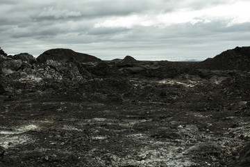 Leirhnjukur old black lava field in Iceland, overcast day in summer , moody film effect with grain