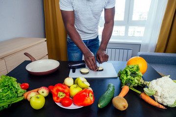 afro male hamds cutting apple,eggplant and kivi
