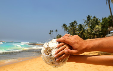 Wedding couple holding hands on tropical background. Two hands wearing wedding rings in honeymoon trip in Sri Lanka. 