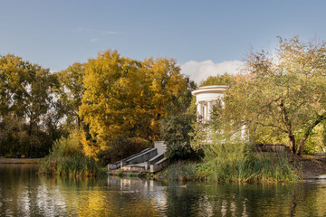 Obraz na płótnie Canvas Old park in fall. View of lake and white rotunda.
