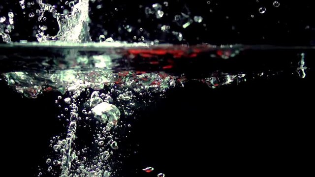 Paprika splashing into water on black background closeup in super slow motion - Powered by Adobe