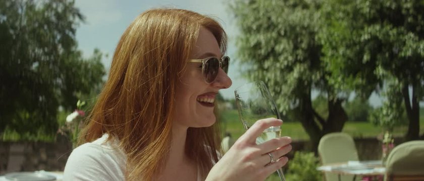 Women sitting on a restaurant&rsquo;s patio in the countryside on a summer day drinking white wine - Frau sitzt auf der Terrasse eines naturnahen Restaurantes und trinken Wei&szlig;wein unter der Sonne