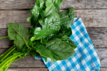 Raw spinach on wooden background