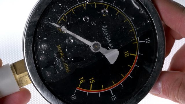 the worker holds a pressure gauge in his hands and twists it, checking for the presence of fluid inside, usually glycerin is poured into such sensors so that the arrow does not tremble