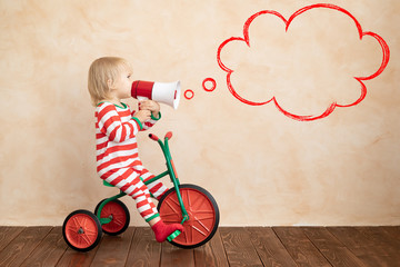 Happy child dressed Santa Claus costume playing at home