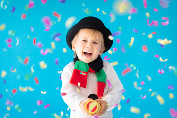 Happy child wearing snowman holding party popper