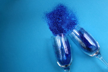 on a blue background from two glasses sparkles scattered