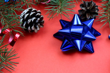 Christmas texture fir branches, toys and cones on a red background