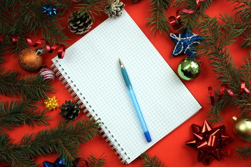 notebook with pen lies on the background of Christmas decoration