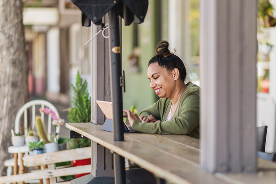 Woman Using Computer At Outdoor Cafe