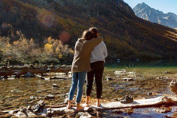 two girls on an autumn mountain lake