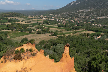 Roussillon ochre deposit red hills and green pines forest in Luberon