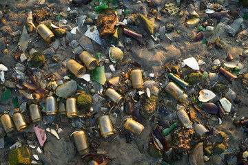 Glass bottles litter the beach and glimmer in the evening sunlight
