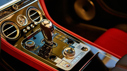 Automatic gear shift handle. Red luxury car Interior. Shallow doff.