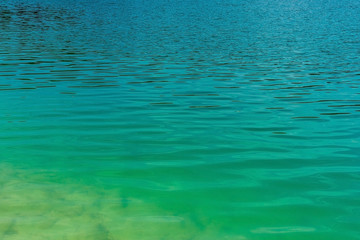 light green water ripple background, emerald lake shore