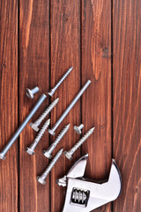 Set of nails and tools on a brown wooden background