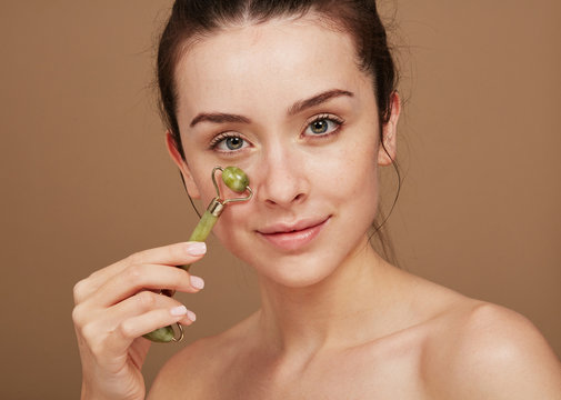 Beautiful woman using Jade Roller