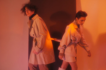 Young couple in coats tied with belts