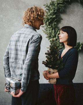 Young couple with Christmas tree and gift