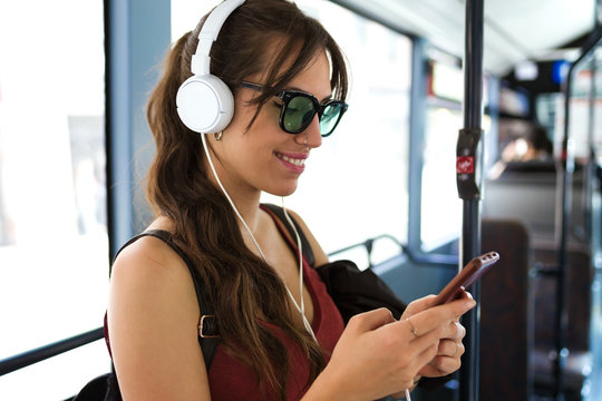 Contemporary happy woman with phone in bus