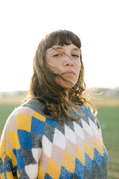 Young woman in colorful sweater in sunlight