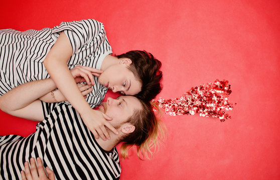 Young couple lying near glittering heart