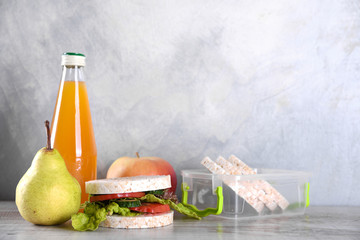 lunch for your child in school, box with a healthy sandwich and fruit salad and apple juice in the bottle for drinking