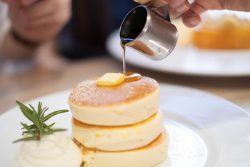 Honey pancakes and butter on the white dish.