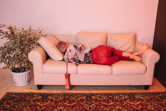 Sleeping woman on sofa with phone headset