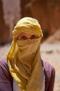 Portrait of the female tourist with a tied yellow berber tagelmust scarf. 